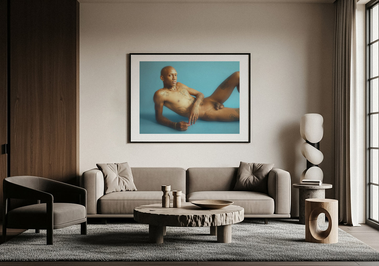 Living room with a gray sofa, coffee table, and wall art of a nude figure. Photography by Lucas Castro Pardo