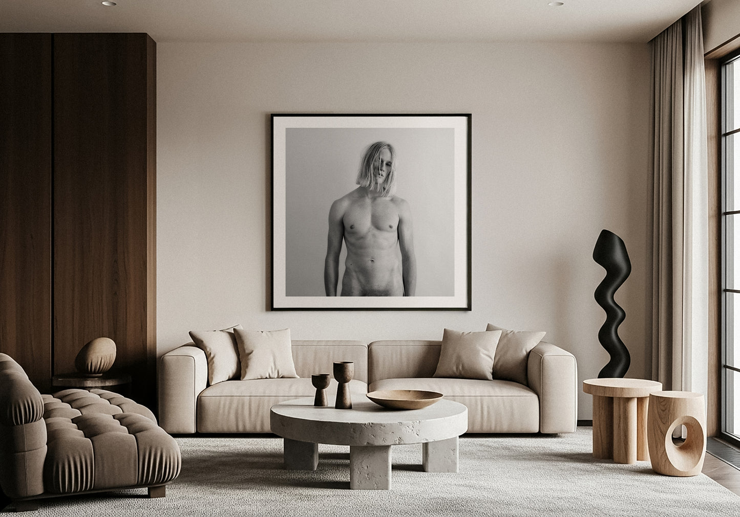 Modern living room with a framed black and white fine art portrait on the wall, a sofa, and decorative items.