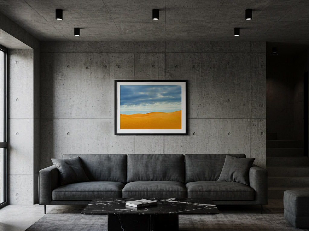 Modern living room with a gray sectional sofa and a framed dunes landscape fine art print