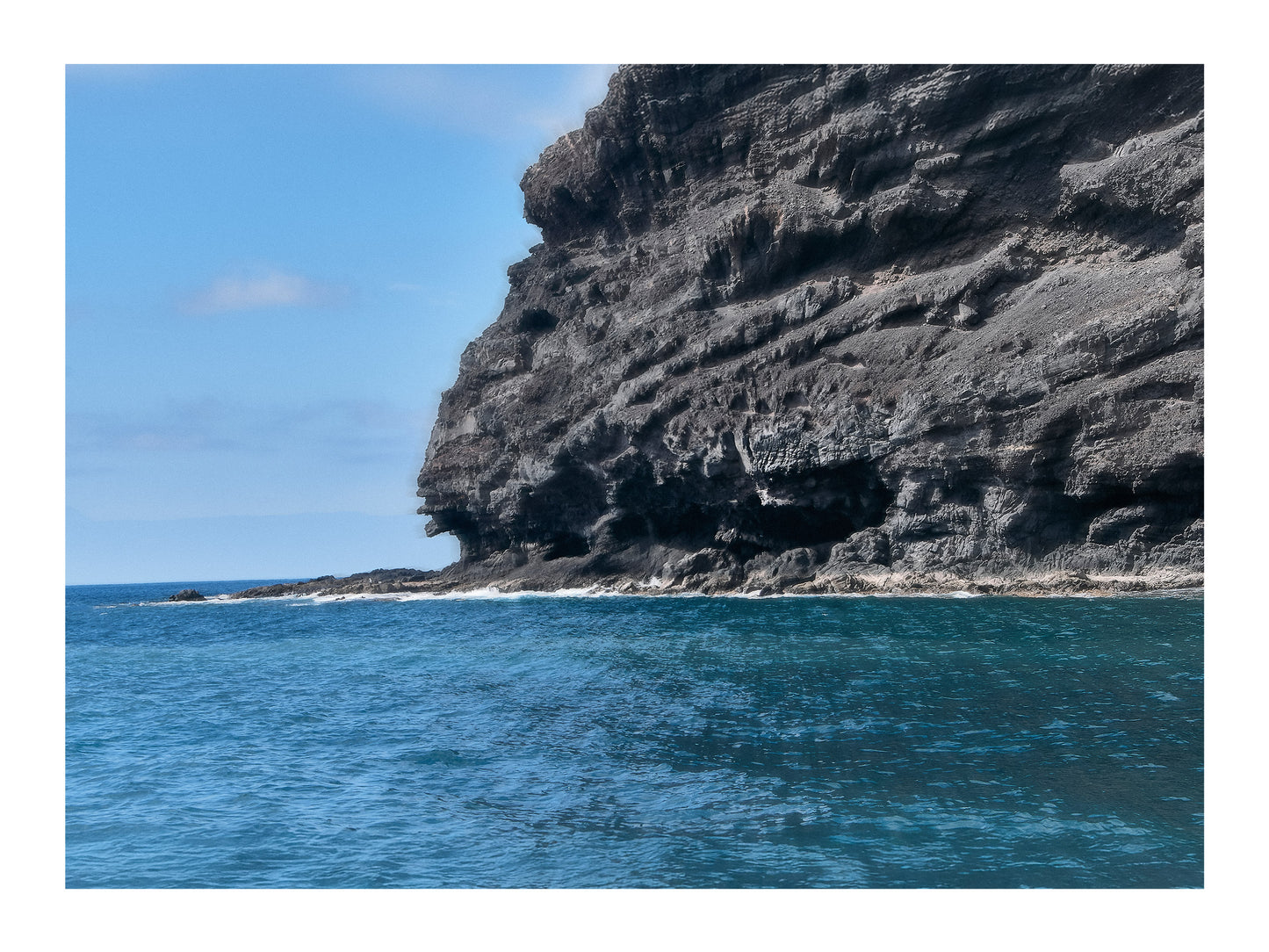 Fine Art Landscape Photography of a Stony cliff by the sea under a clear blue sky