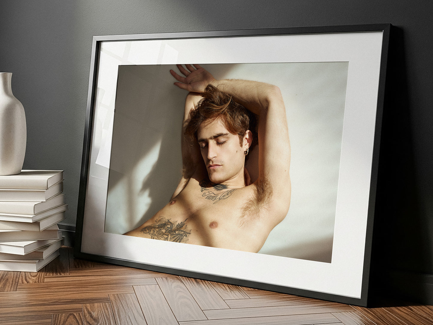 Framed fine art portrait of a shirtless man with tattoos leaning against a wall, placed on a wooden floor. Limited Edition, signed and numbered.