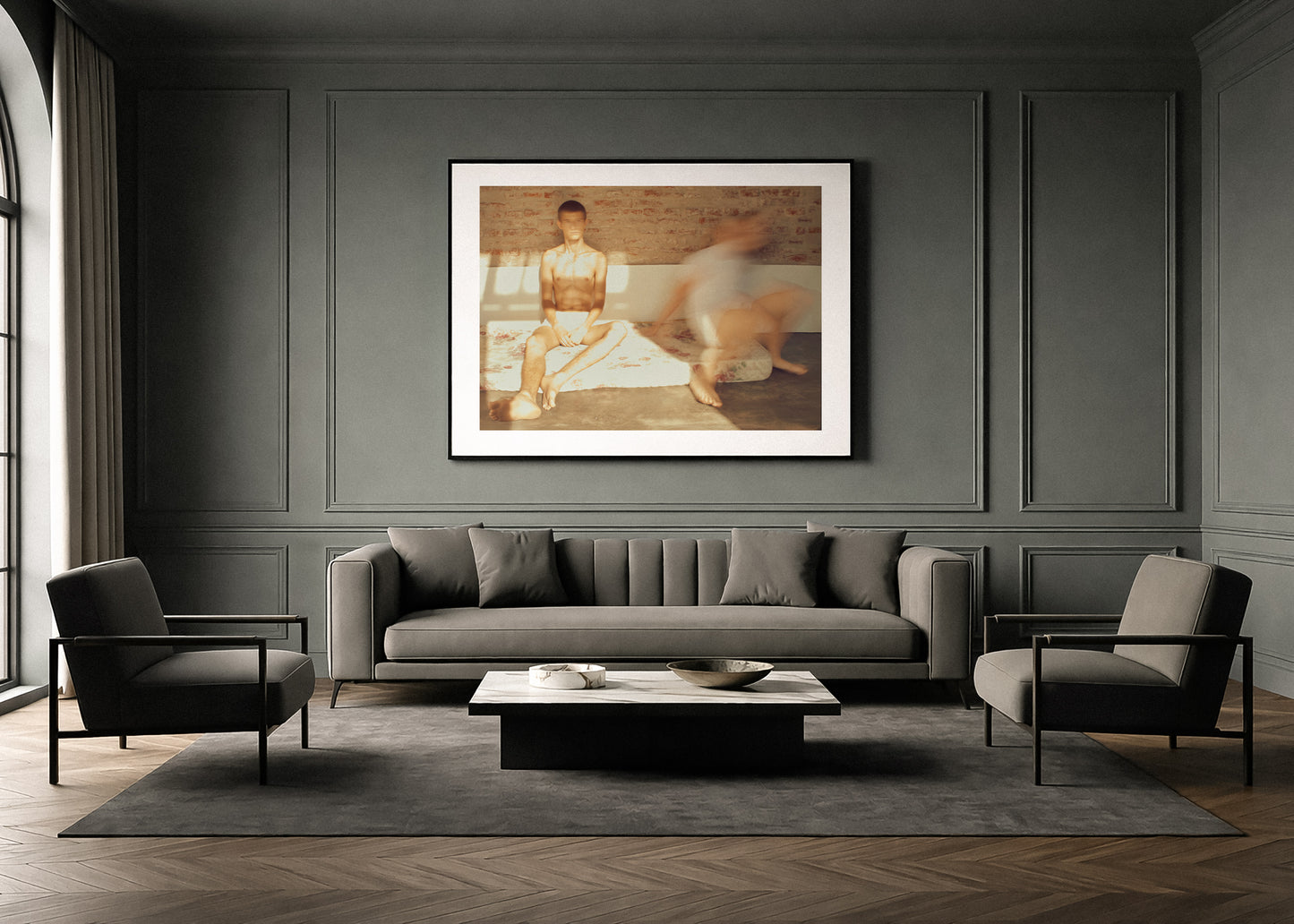 Modern living room with gray sofa, armchairs, and a framed fine art picture on the wall.