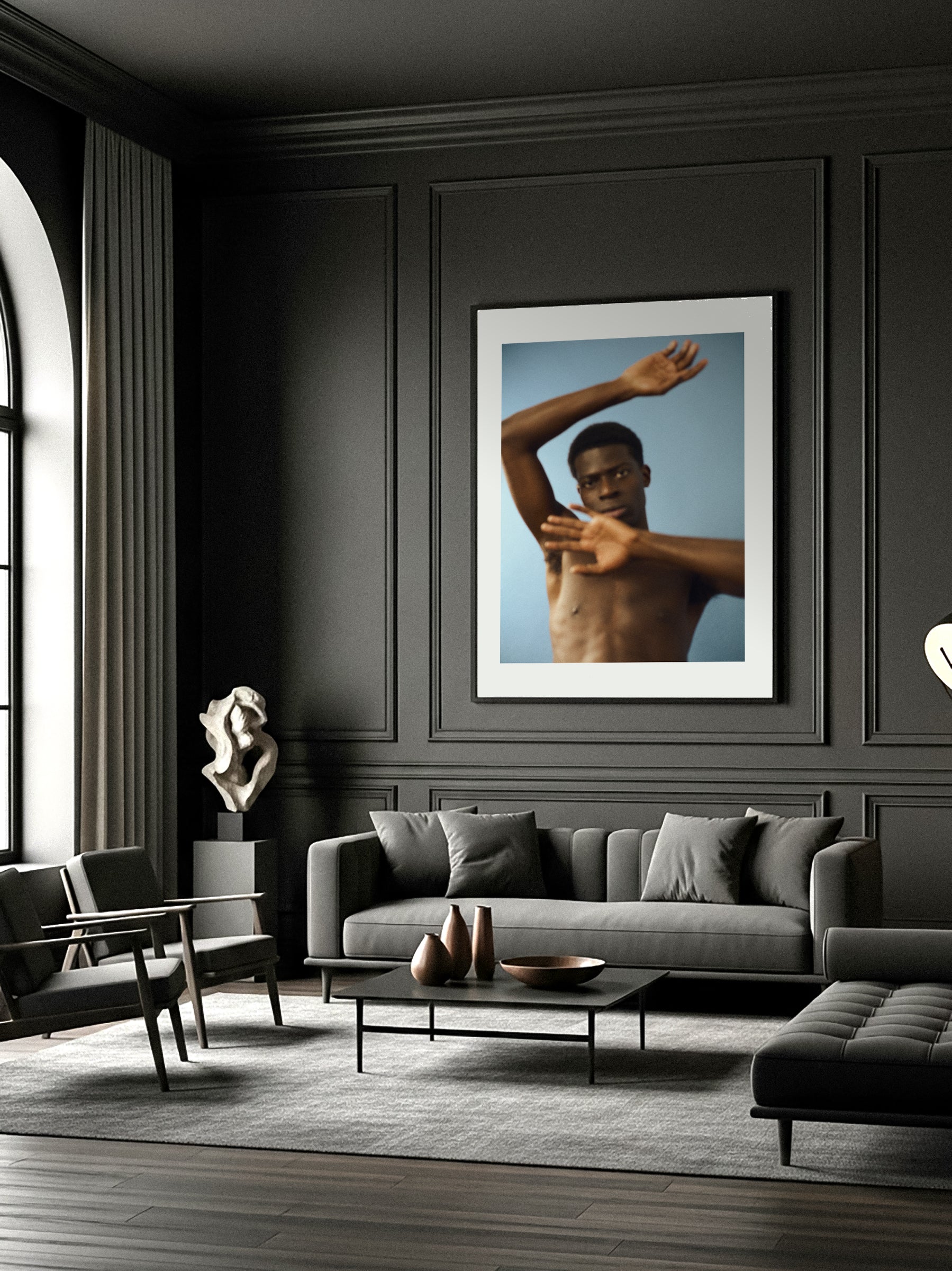 Modern living room with a gray sofa, coffee table, and a fine art print wall art of a shirtless man.