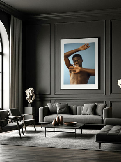 Modern living room with a gray sofa, coffee table, and a fine art print wall art of a shirtless man.