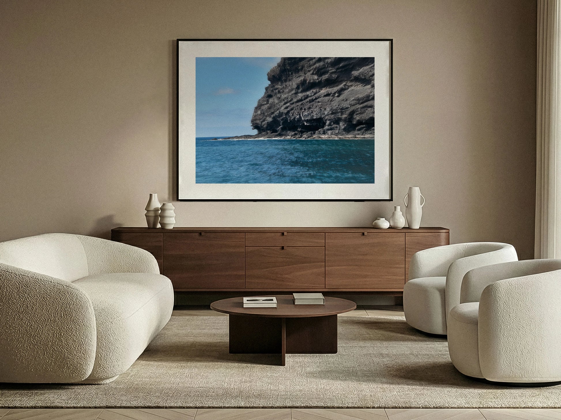 Modern living room with a large framed fine art picture of a volcanic coastal scene on the wall.
