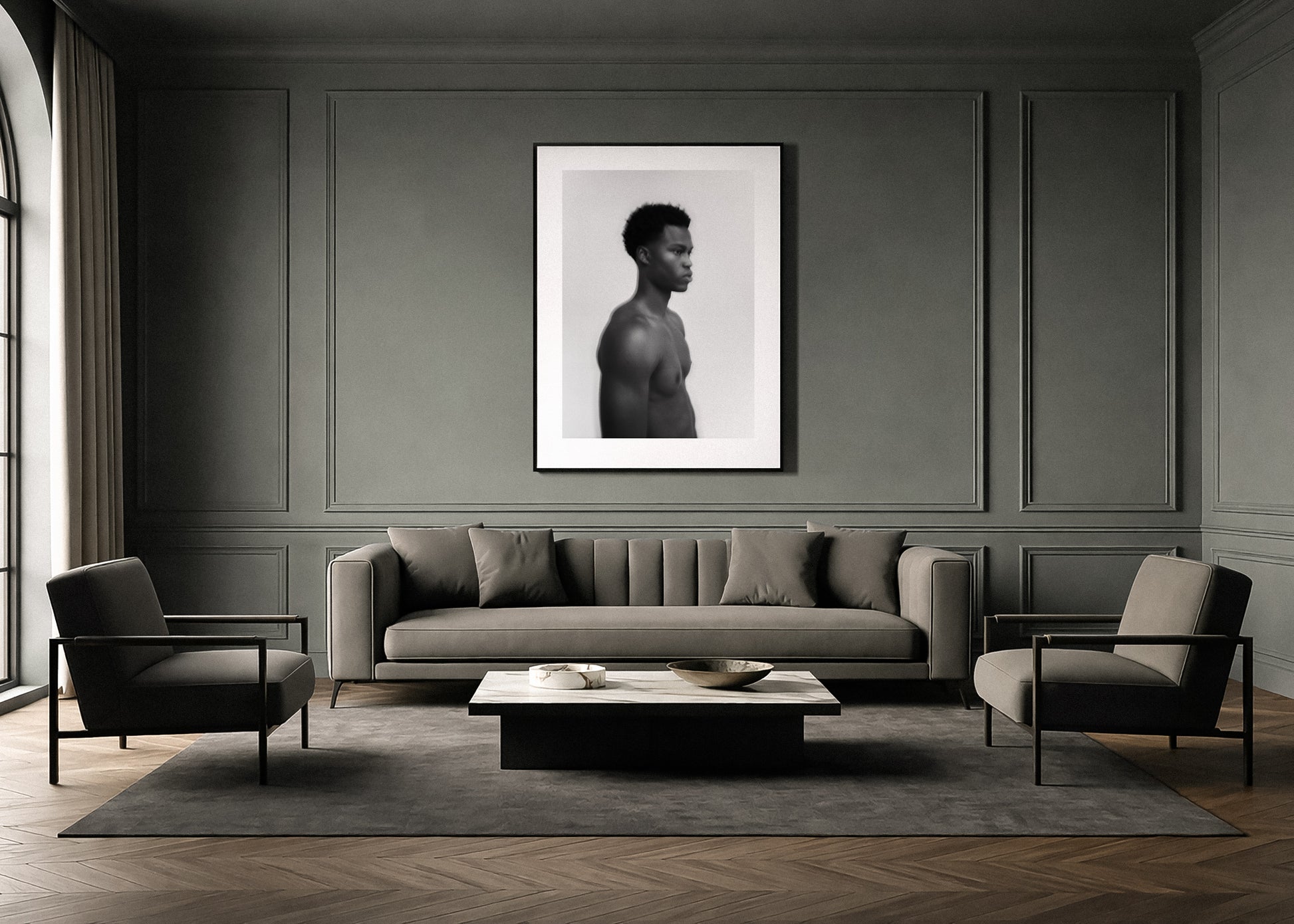 Modern living room with a gray sofa, chairs, and a framed black and white fine art portrait on the wall.