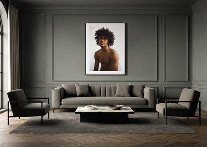 Modern living room with a gray sofa, chairs, and a large framed portrait on the wall.