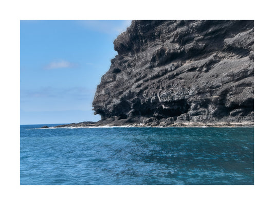 Fine Art Landscape Photography of a Rugged cliff face over blue ocean with clear sky. 