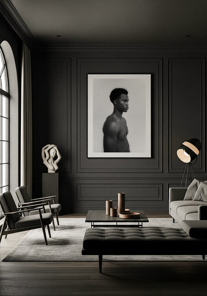 Modern living room with dark walls, furniture, and decor elements. Framed fine art photography of a young man in black and white